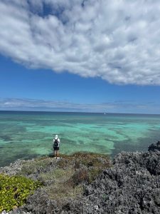 Fisherman spotting for cruising tarpon from a rocky cliff above the reef flat in Grand Cayman, Cayman Islands